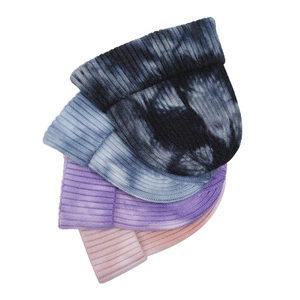 Detail of multi-colored tie-dye ribbed knit beanies in grey, blue, purple, and pink colors