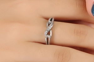 Close-up of a silver infinity ring in titanium steel featuring delicate zircon stones