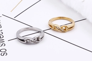 Macro detail of infinity sign rings with sparkling zircons and textured metal bands