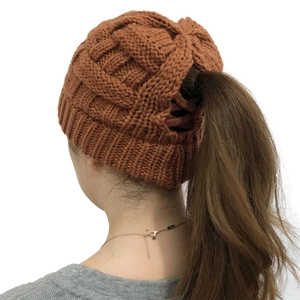Detail of knitted ponytail beanie in caramel brown featuring top opening for hair