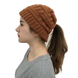 Detail showing the ponytail hole design and ribbed texture on the caramel knit beanie