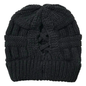 Detail of black knit ponytail beanie featuring criss cross back opening and ribbed cuff