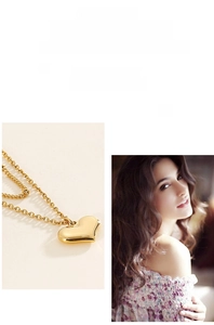 Detail einer zweischichtigen goldperlenkette mit herzanhänger an einem modell getragen