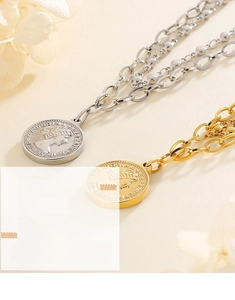 Detailed macro of layered metal chain necklace with queen portrait coin pendant