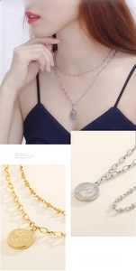 Close-up of double-layer chain necklace with embossed queen coin pendant in gold and silver