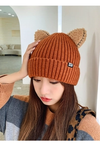 Close-up of the orange knit hat showing the CAT label and cute animal ear details