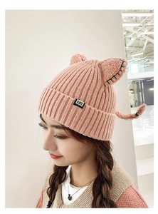 Detail of pink knitted cat ear beanie showing the cute design and black CAT woven label