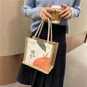 Detail of canvas tote bag with orange illustration and durable cotton rope handles