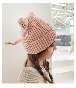 Detail view of pink knitted cat ear beanie with fuzzy lamb wool lining for women