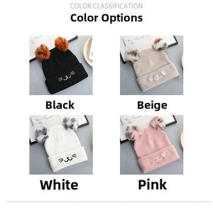 Detail view of cat knit hats in black, beige, white and pink with dual pom poms