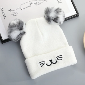 Cute white knitted cat ear beanie with faux fur pom-poms and embroidered cat face details