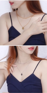 Model wearing gold and silver layered necklaces with minimalist round disk pendants