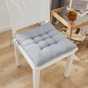 Thick grey square seat cushion with tufted design and secure ties for dining chairs