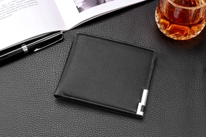 Men's minimalist black leather bifold wallet with silver metal trim in a professional setting
