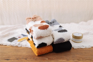 Close-up of soft coral fleece thermal socks featuring cute cat patterns and cat ear details