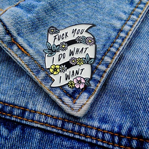 Enamel ribbon brooch with floral design on denim jacket featuring bold punk slogan