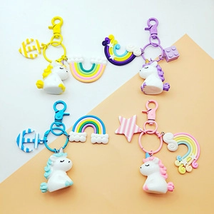 Flat lay view of four colorful unicorn keychains with rainbow and star charms