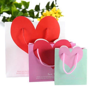 Three sizes of heart-patterned paper gift bags in white, purple and mint green colors