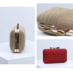 Detailed view of the bow-shaped metal clasp and pleated sequin fabric on the evening bag