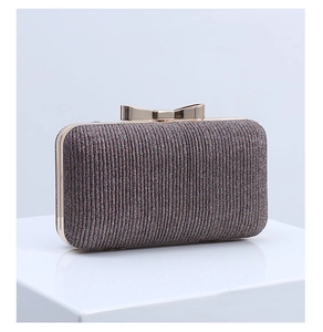 Macro shot of dark grey glitter clutch with vertical pleats and golden bow clasp