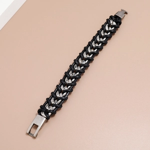 Close-up of woven black leather rope and silver metal chain link bracelet for men
