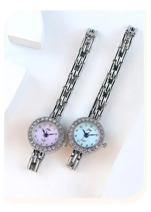 Detail of luxury rhinestone quartz watches with pink and blue gradient dials and silver bands
