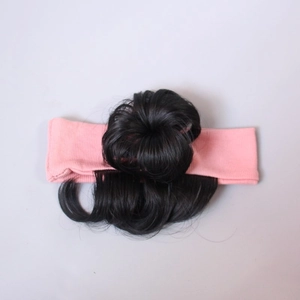 Detail eines synthetischen schwarzen Haarknotens und rosa Strick-Stirnbands für Kinder