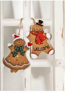 Close-up of wooden gingerbread man and girl ornaments with rustic twine hanging on window