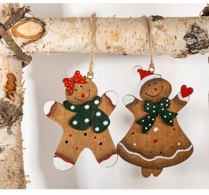 Detail of wooden gingerbread man and girl ornaments with red bow and green scarf