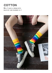 Detail shot of rainbow striped cotton socks worn by a model in casual street style outfit