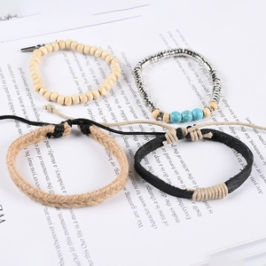 Multilayer leather bracelet set with turquoise beads and feather charms on a book