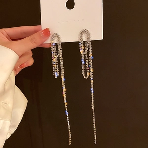 Macro shot of sparkling silver rhinestone tassels on long geometric drop earrings