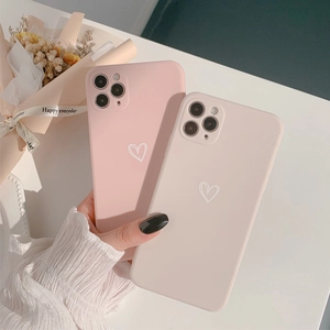 Detailed view of matte pink and cream phone cases with minimalist heart patterns