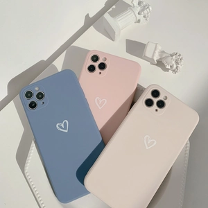 Detail of matte heart pattern iPhone cases in blue, pink, and beige on a white tray