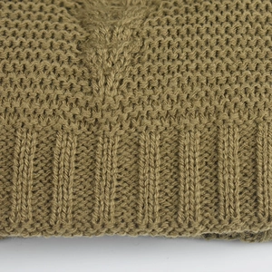 Macro shot of khaki cable knit pattern and ribbed cuff detail on winter beanie