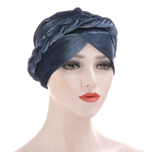 Detailed close-up of blue velvet turban hat with stylish braided twist knot design