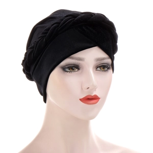 Close-up of black velvet turban cap featuring intricate twisted braid design at the front
