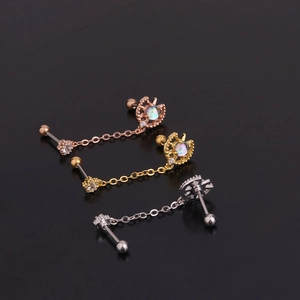 Detail of opal moon piercing studs in gold, silver and rose gold with chain links