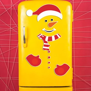 Detail of Christmas snowman magnetic stickers including hat and scarf on yellow fridge