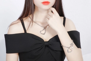 Detail of silver heart pendant necklace and bracelet set with pearl and OT buckle