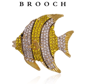 Macro detail of tropical fish brooch with sparkling yellow and silver rhinestones