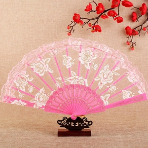 Pink lace folding fan with rose patterns on a display stand for traditional dance