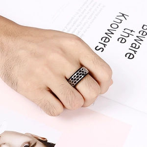 Men's punk stainless steel ring with honeycomb pattern shown on hand over a magazine