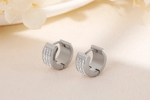 Detailed close-up of wide hoop earrings with triple rows of paved white zircons