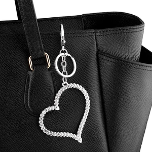 Porte-clés cœur scintillant avec strass sur un sac à main en cuir noir élégant