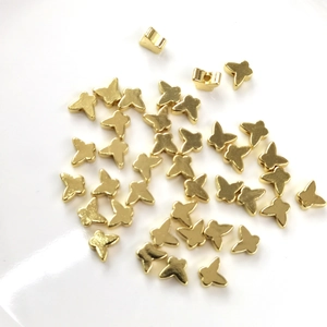 Macro detail of 14K gold filled butterfly spacer beads for DIY jewelry making crafts