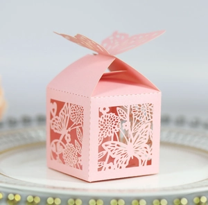 Macro view of pink laser-cut paper gift box featuring butterfly and floral patterns