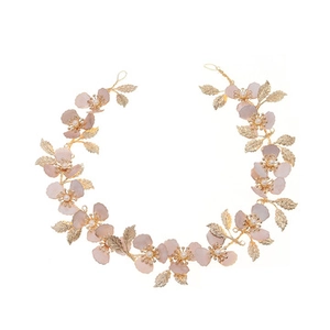 Detail of luxury bridal headband with gold leaves, pink resin petals and clear beads