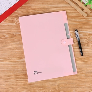 Porte-documents A4 rose avec fermeture à bouton et onglets sur bureau en bois