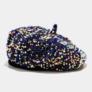 Detailed close-up of dark blue velvet beret featuring vibrant holographic sequins